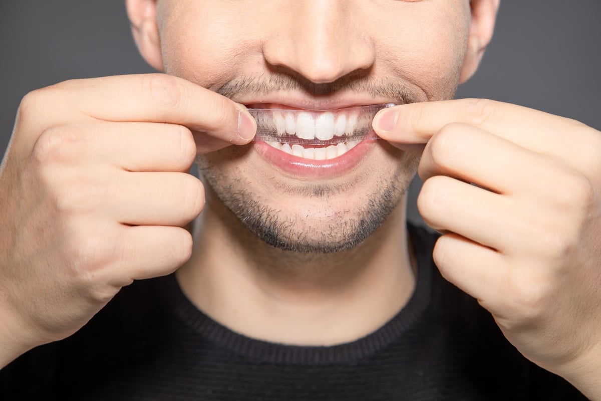 Applying a whitening strip to the teeth